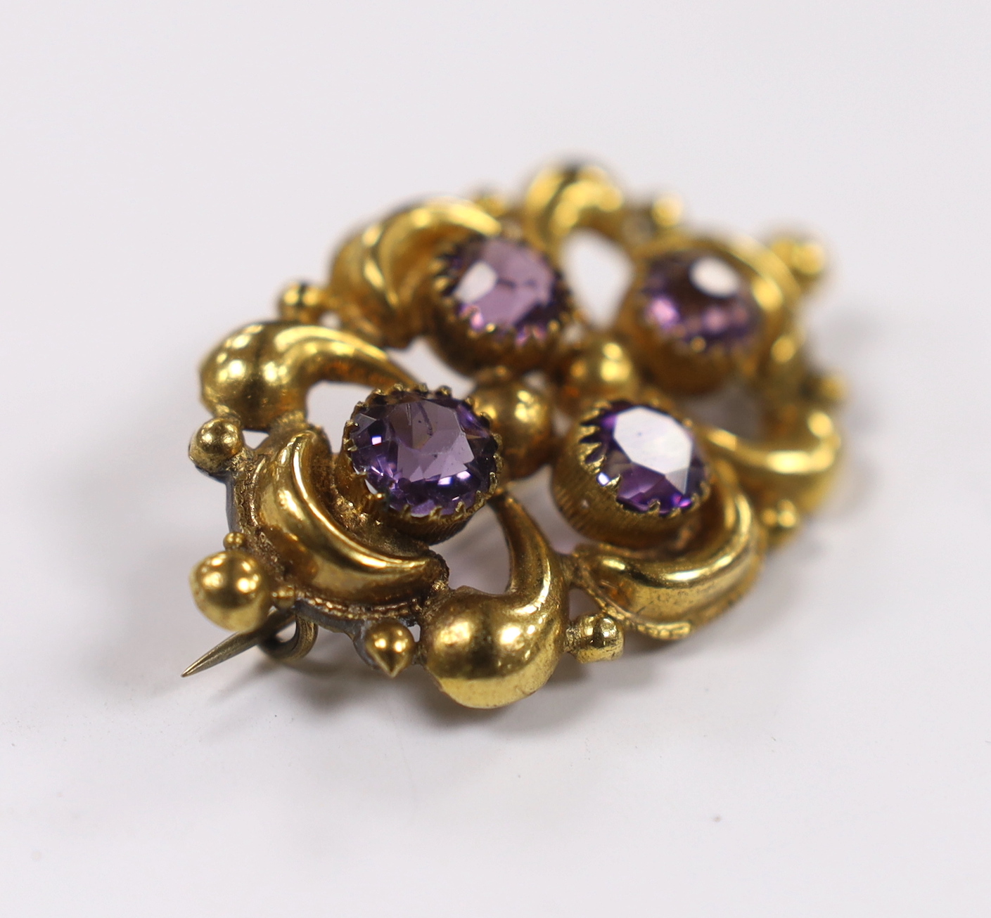 A late Victorian yellow metal and amethyst cluster set oval brooch, 45mm, gross weight 7.2 grams.